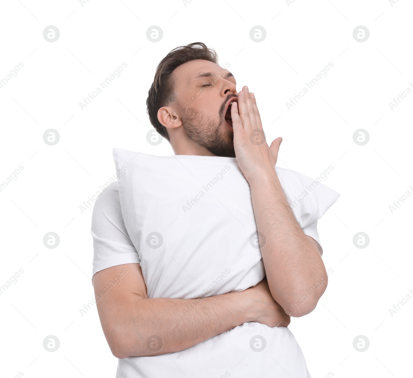 Photo of Sleepy man with pillow yawning on white background. Insomnia problem