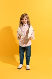 Photo of Fashion concept. Stylish girl posing on yellow background