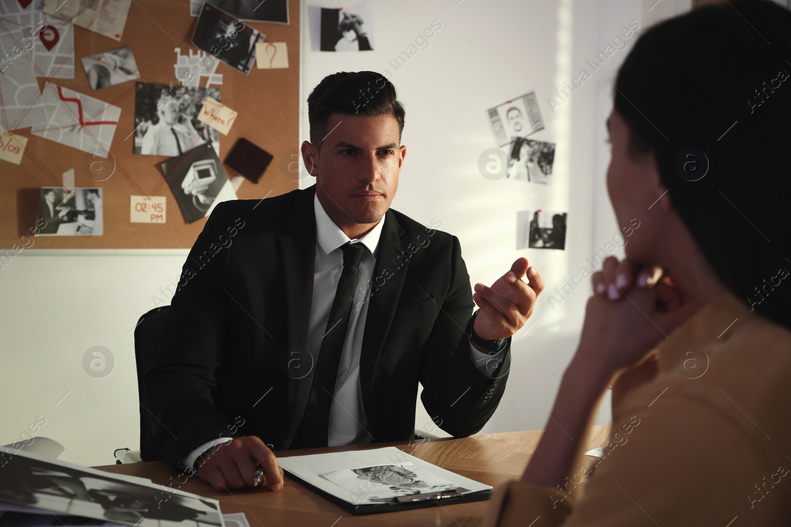 Photo of Detective working with client in his office