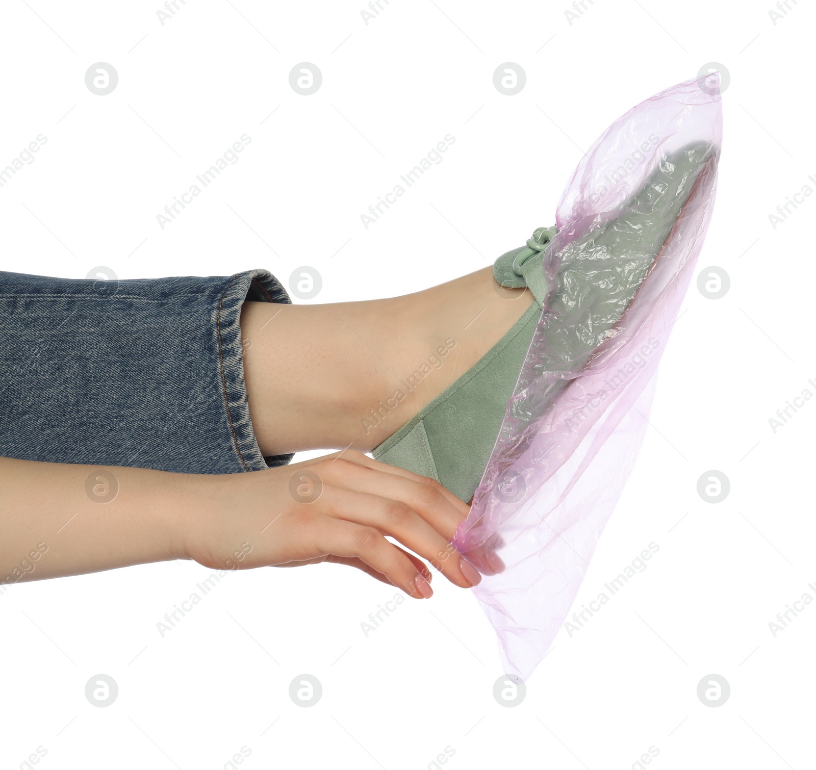 Photo of Woman wearing shoe cover onto her footwear against white background, closeup