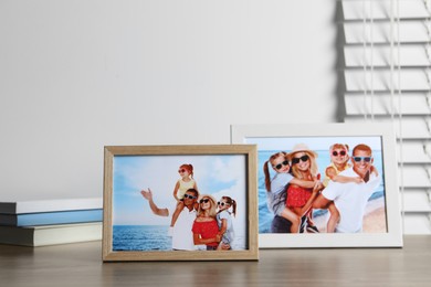 Frames with family photos on wooden table indoors