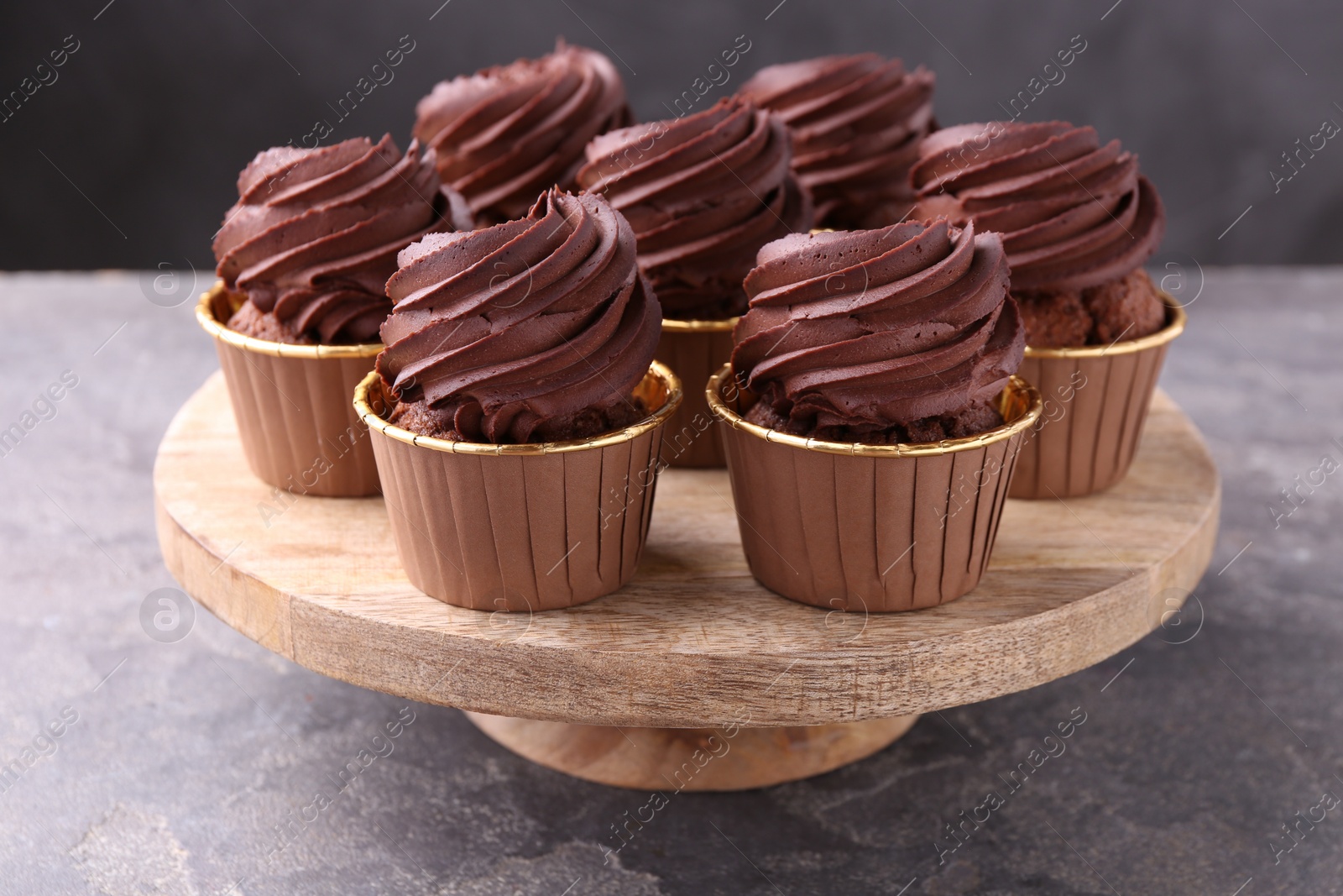 Photo of Delicious chocolate cupcakes on grey textured table