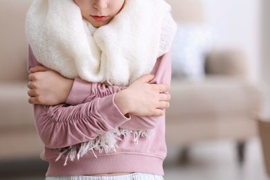 Photo of Little girl suffering from cold on blurred background