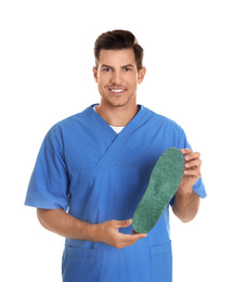 Male orthopedist showing insole on white background