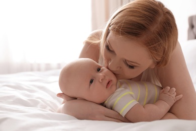 Photo of Mother with her little baby on bed at home
