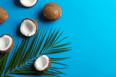 Flat lay composition with coconuts and palm leaf on color background. Space for text