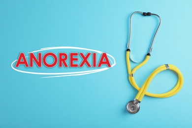 Anorexia concept. Stethoscope on light blue background, top view 