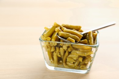 Photo of Canned green beans in bowl on wooden table