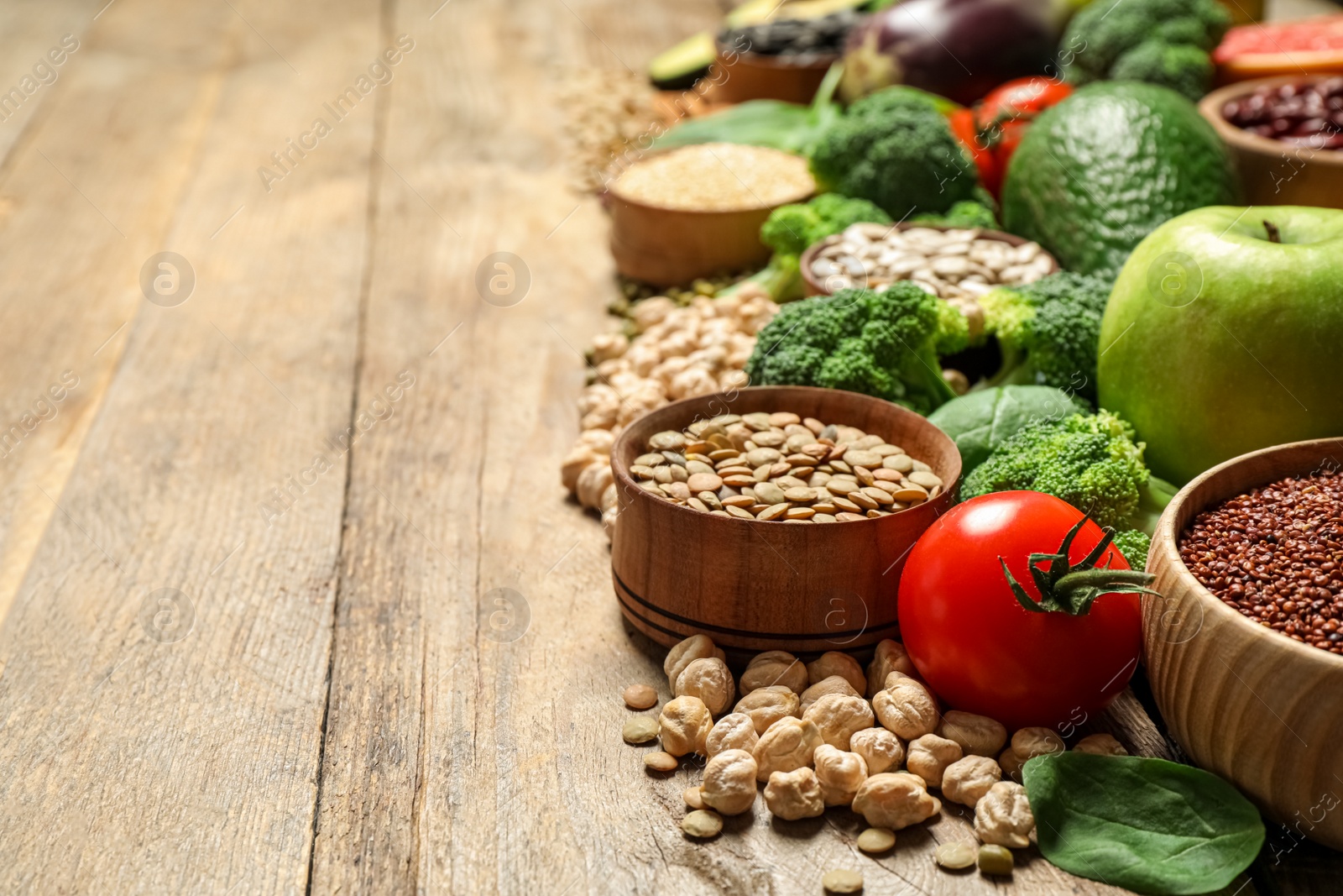 Photo of Different vegetables, seeds and fruits on wooden table, space for text. Healthy diet