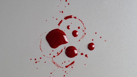 Photo of Stain and splashes of blood on grey background, top view