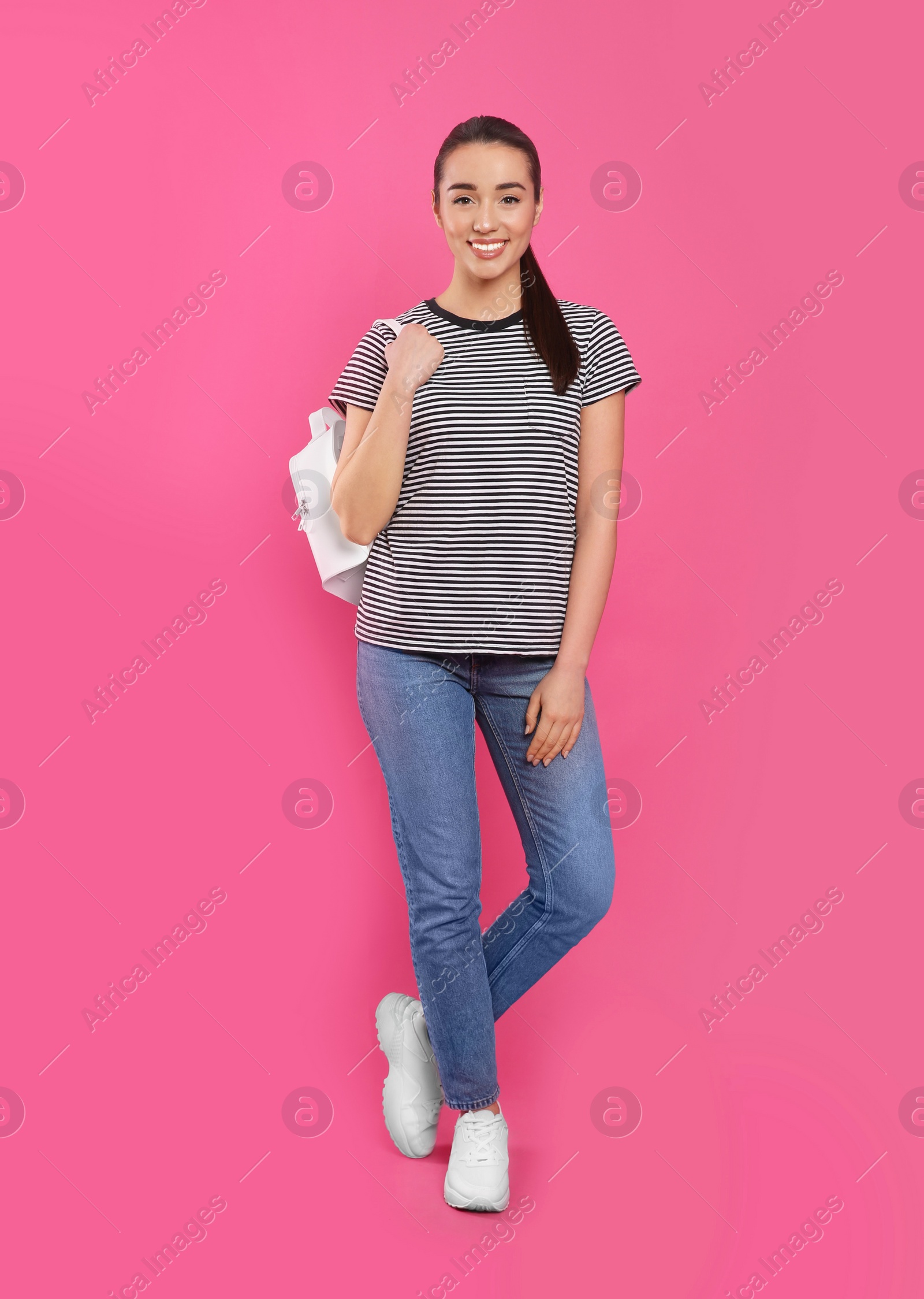 Photo of Beautiful young woman with stylish leather backpack on pink background