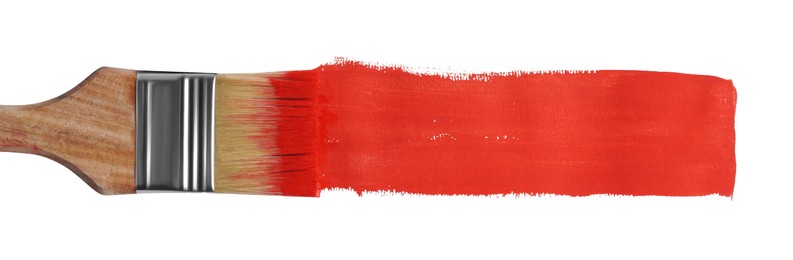 Red paint stroke and brush on white background, top view