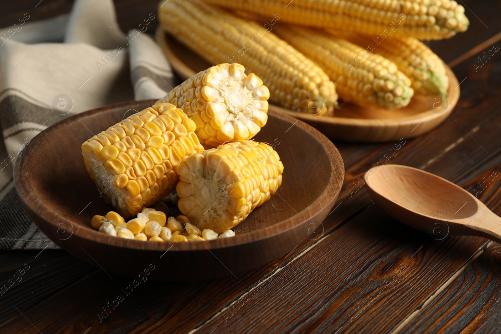 Photo of Tasty sweet corn cobs on wooden table