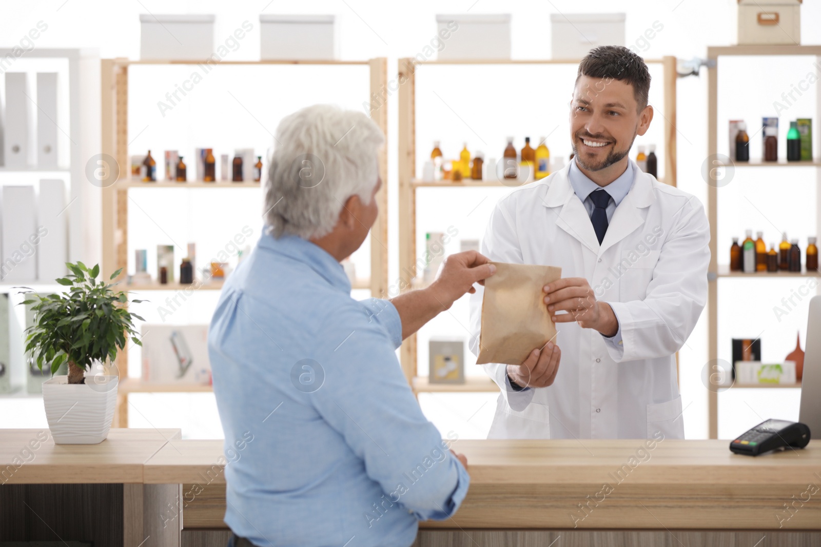 Photo of Pharmacist giving medicine to customer in drugstore