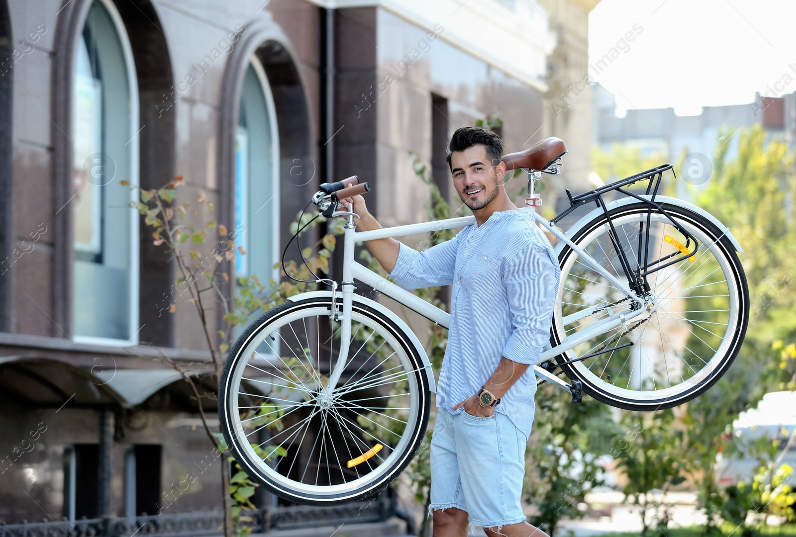 Photo of Handsome young hipster man with bicycle outdoors