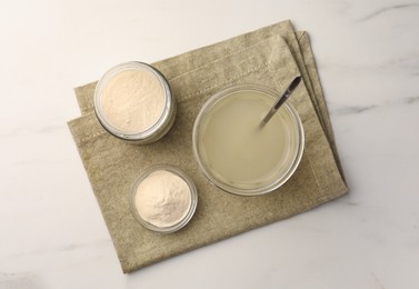 Photo of Agar-agar jelly and powder on white marble table, top view