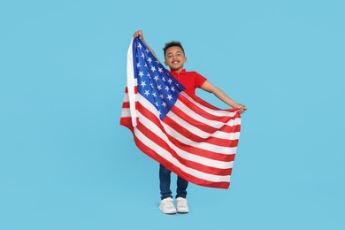 Photo of 4th of July - Independence Day of USA. Happy boy with American flag on light blue background