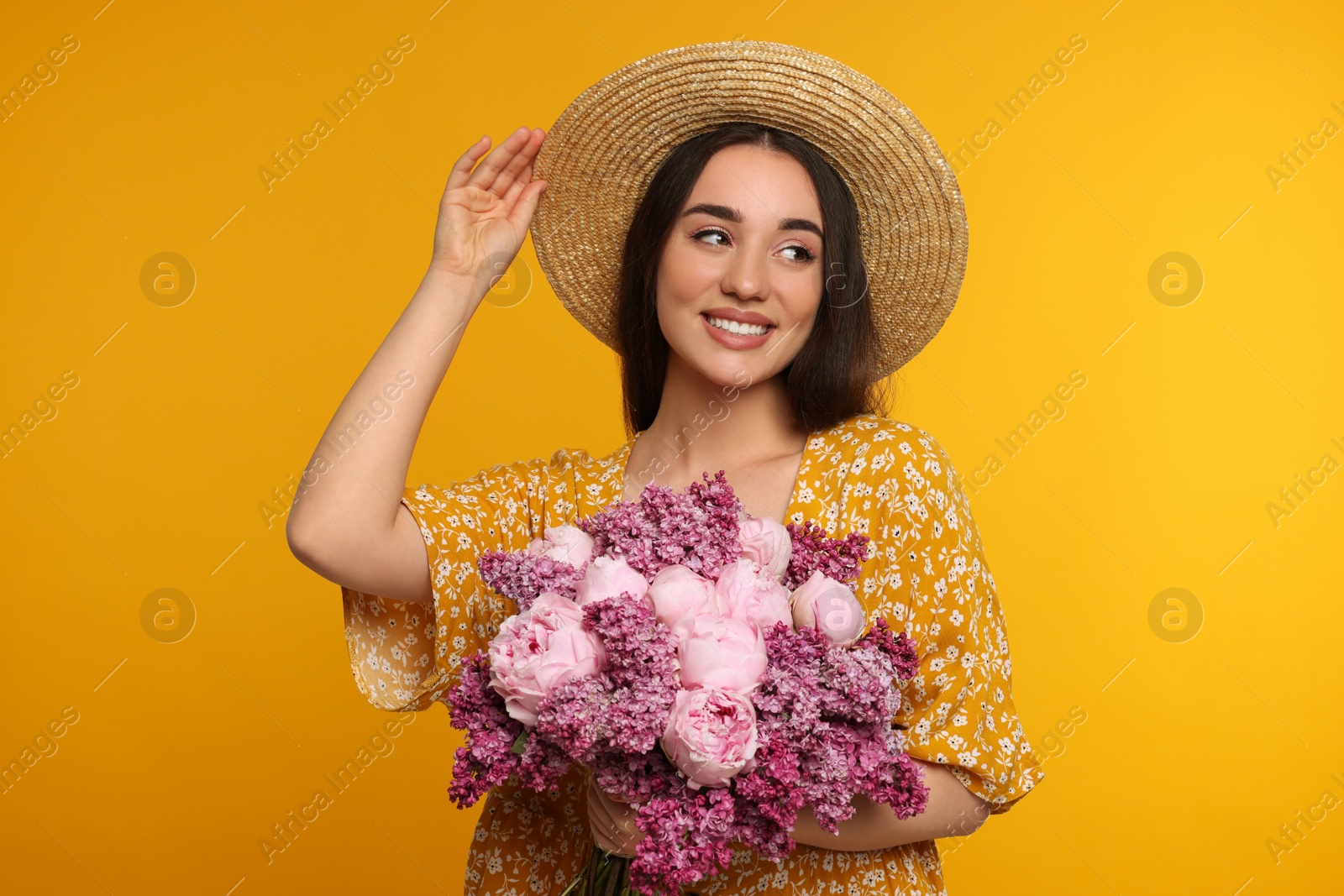 Photo of Beautiful woman with bouquet of spring flowers on yellow background