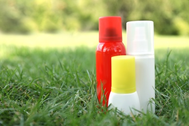 Bottles of insect repellent on green grass