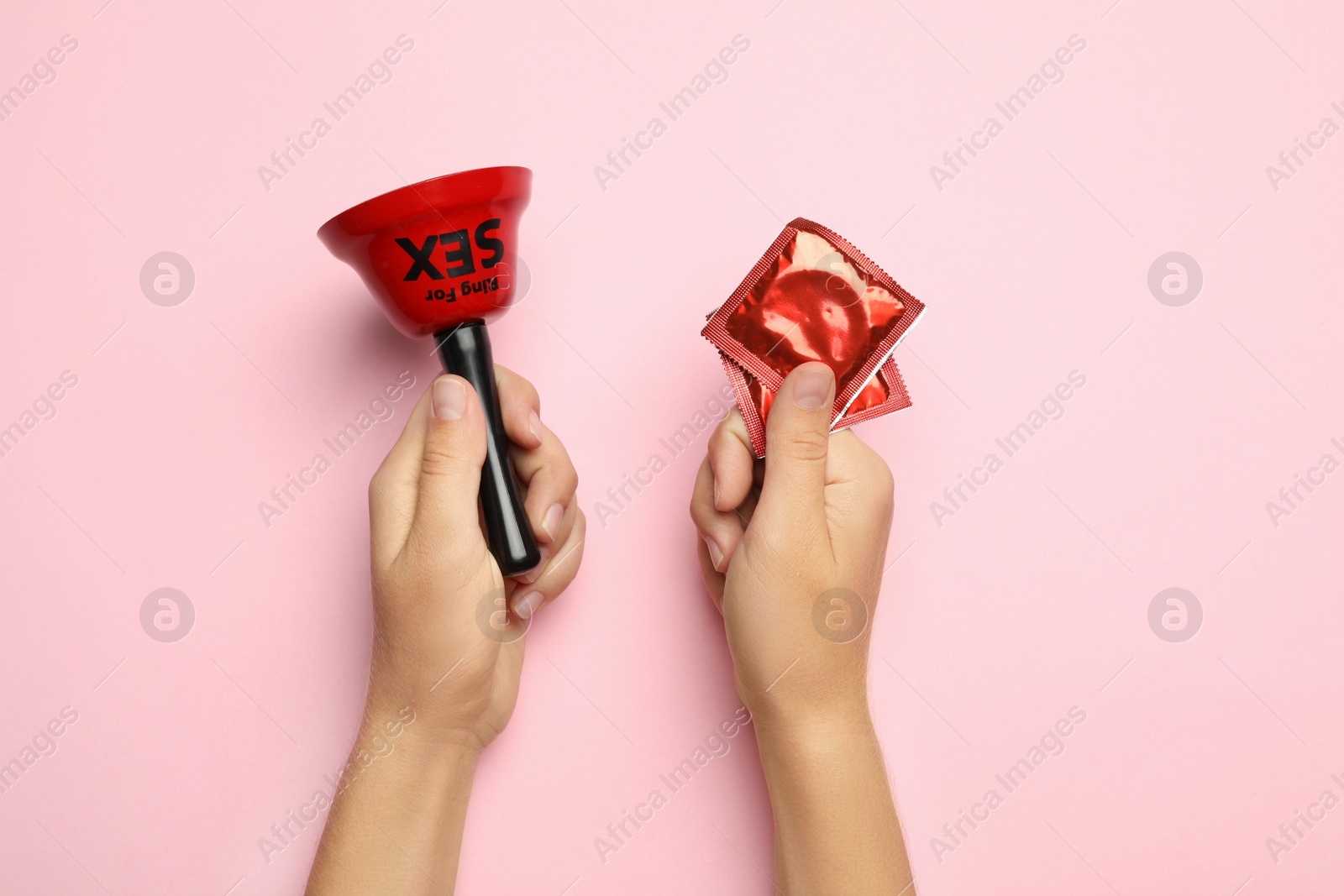 Photo of Woman with sex bell and condoms on pink background, top view