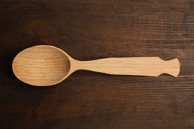 Photo of Handmade wooden spoon on rustic table, top view