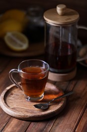 Photo of Glass cup with delicious tea on wooden table