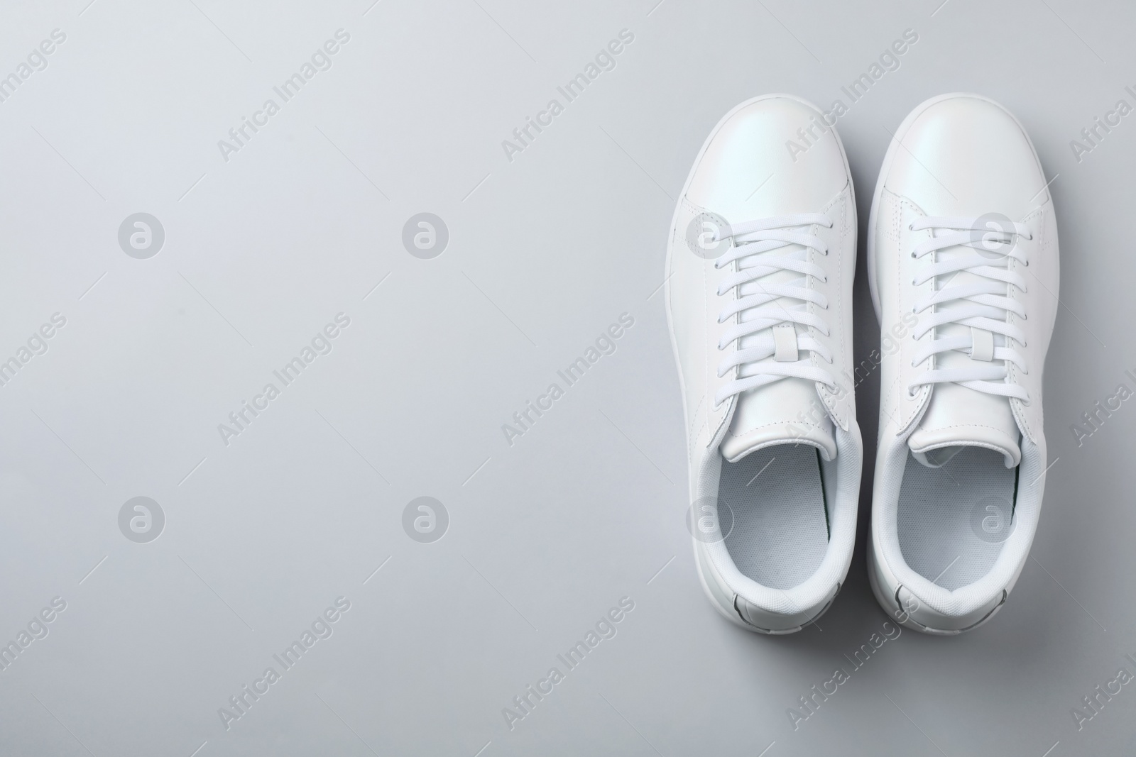 Photo of Pair of trendy sneakers on light background, flat lay. Space for text