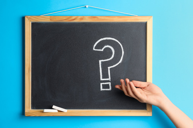 Woman near blackboard with question mark, closeup