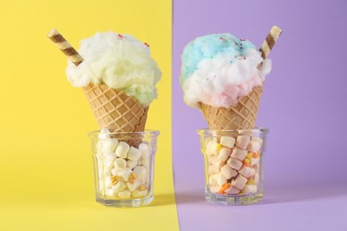 Sweet cotton candies in waffle cones and marshmallows on color background, closeup