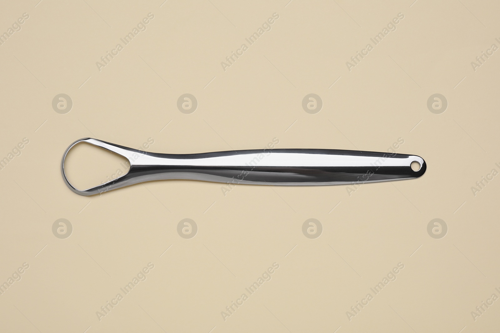 Photo of Metal tongue cleaner on beige background, top view