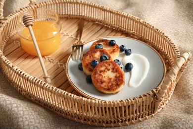 Delicious cottage cheese pancakes with fresh blueberries and sour cream served on tray