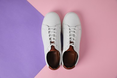 Photo of Pair of stylish white sneakers on color background, flat lay