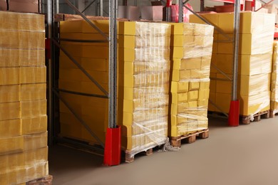 Photo of Warehouse with stacks of boxes on wooden pallets. Wholesaling