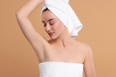 Photo of Beautiful woman showing armpit with smooth clean skin on beige background