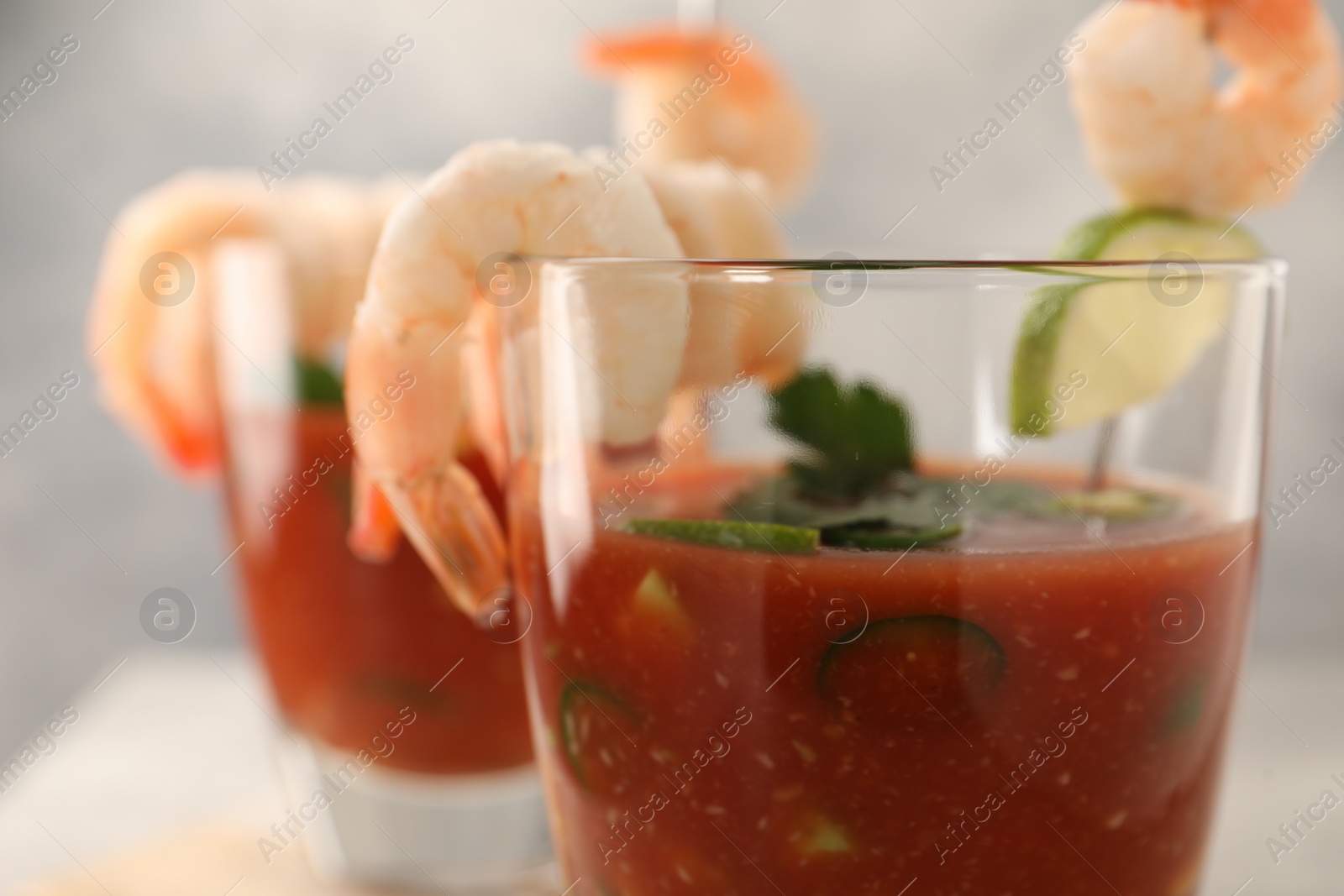 Photo of Tasty shrimp cocktail with sauce in glasses on table, closeup