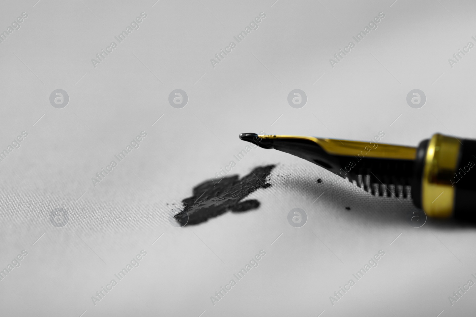 Photo of Pen and stain of black ink on white shirt, closeup. Space for text