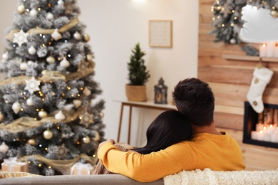 Image of Couple in living room decorated for Christmas