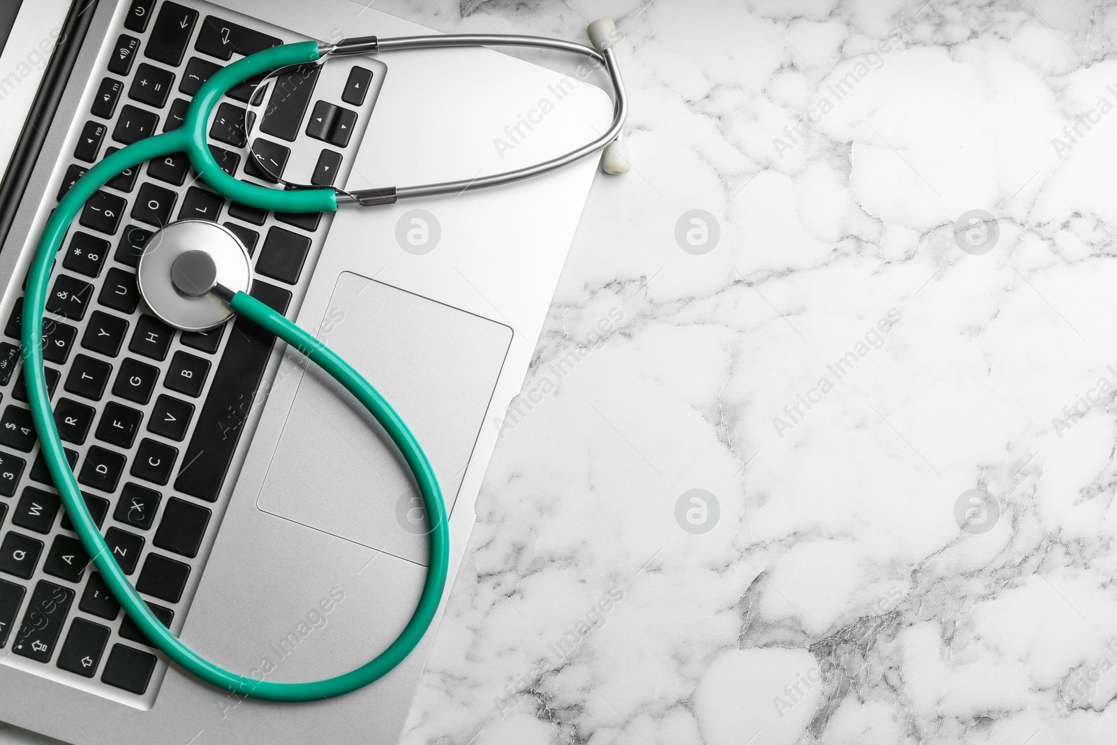 Photo of Keyboard and stethoscope on white marble table, flat lay with space for text. Concept of technical support