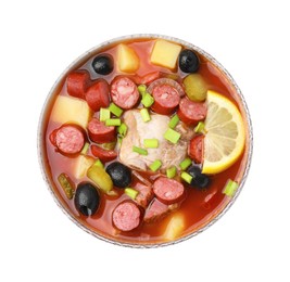 Photo of Meat solyanka soup with thin dry smoked sausages in bowl isolated on white, top view