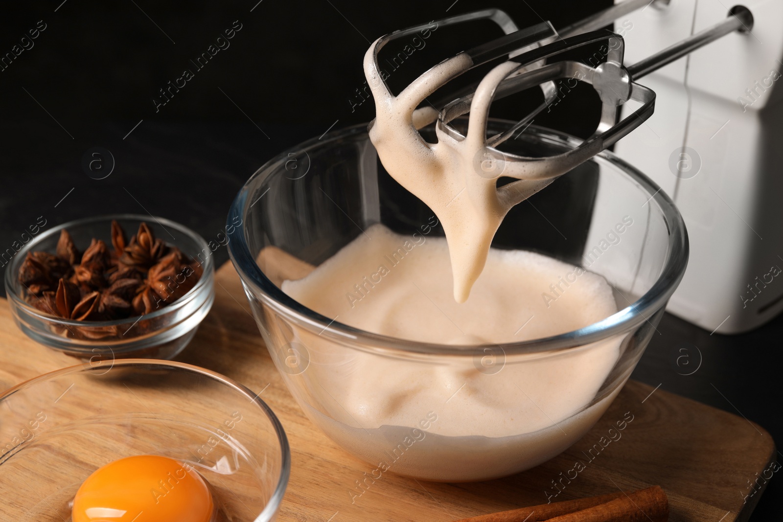 Photo of Different ingredients and mixer on black table. Cooking delicious eggnog