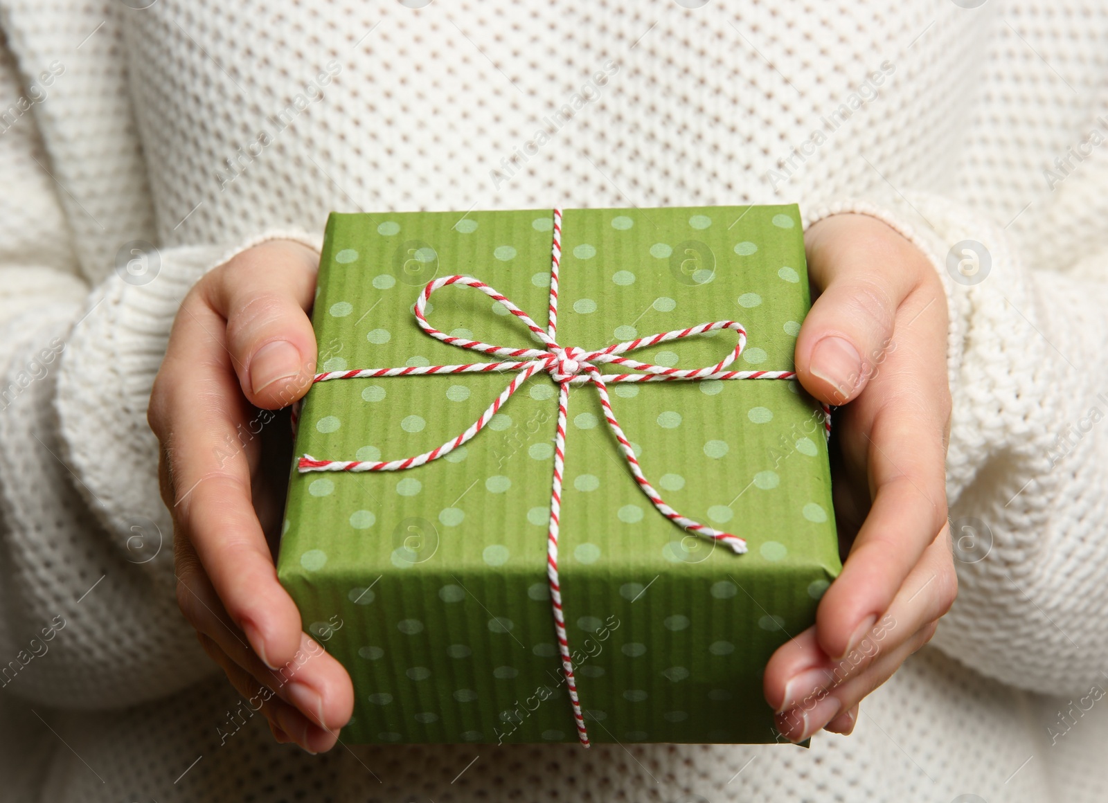 Photo of Woman holding green Christmas gift box, closeup