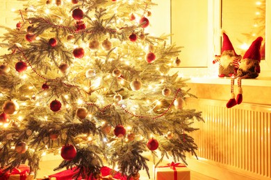 Photo of Beautiful Christmas tree and gifts near window indoors