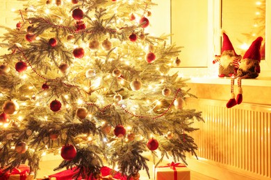 Beautiful Christmas tree and gifts near window indoors