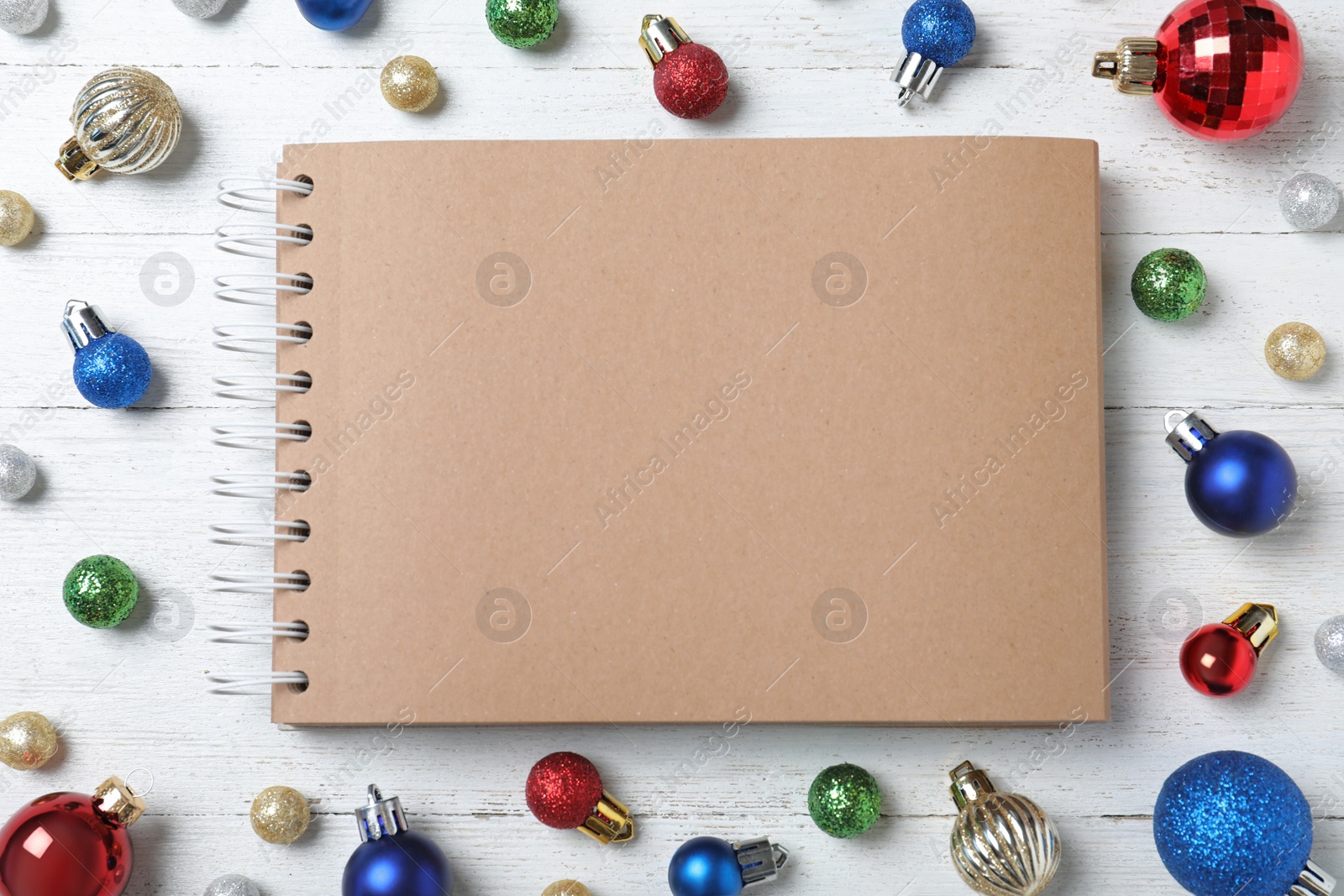 Photo of Flat lay composition with empty notebook and Christmas decorations on white wooden table, space for text. Writing letter to Santa Claus