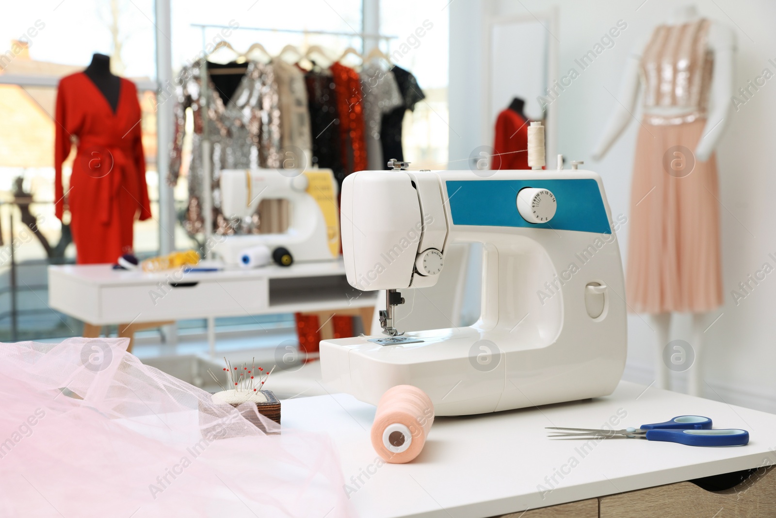 Photo of Sewing machine and equipment on table in dressmaking workshop