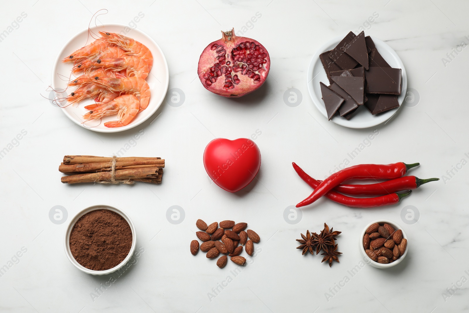 Photo of Natural aphrodisiac. Different products and heart model on white marble table, flat lay