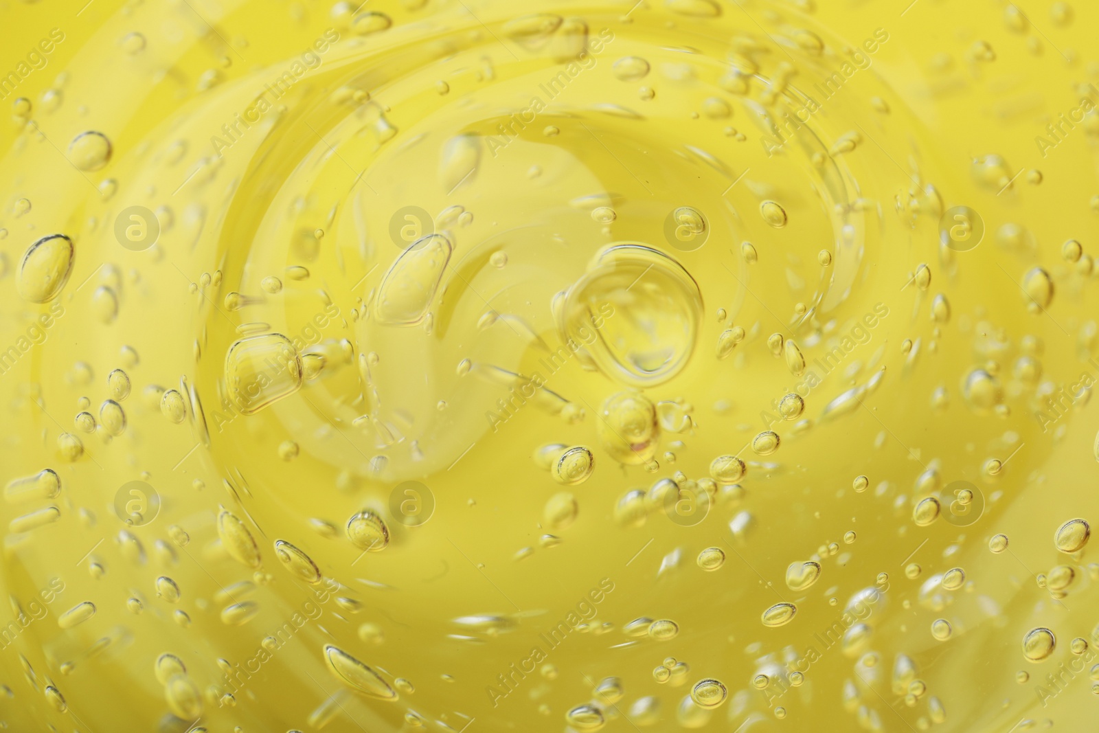 Photo of Pure transparent cosmetic gel on yellow background, closeup