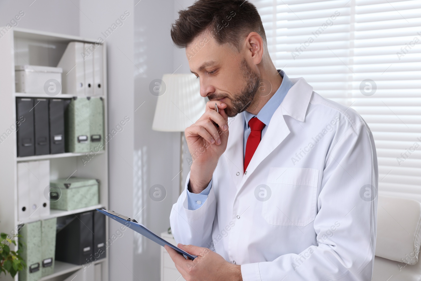 Photo of Doctor with clipboard in clinic. Patient consultation