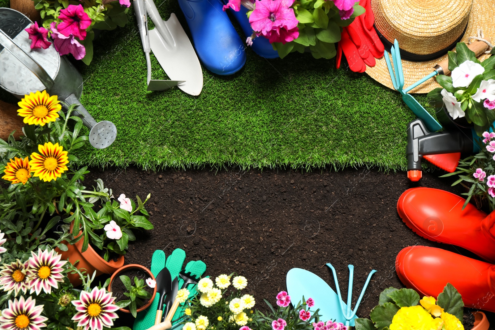 Photo of Flat lay composition with gardening equipment and flowers on soil, space for text