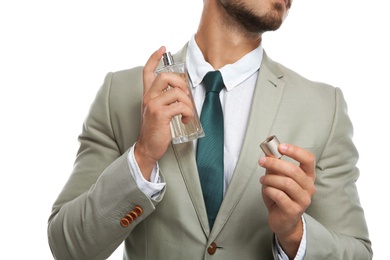 Businessman applying perfume on white background, closeup